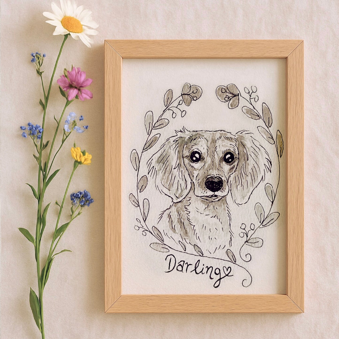 Framed watercolor illustration of a dog with floral elements and the word 'Darling' on a beige wall.