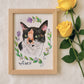 Framed watercolor illustration of a cat with floral elements and yellow roses on a light background